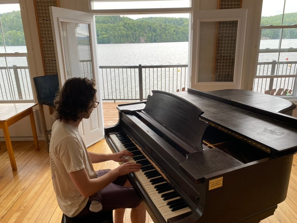 Yannick au piano devant un lac